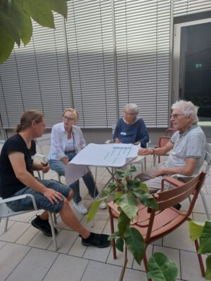Kleine Gruppe an einem Tisch im Innenhof